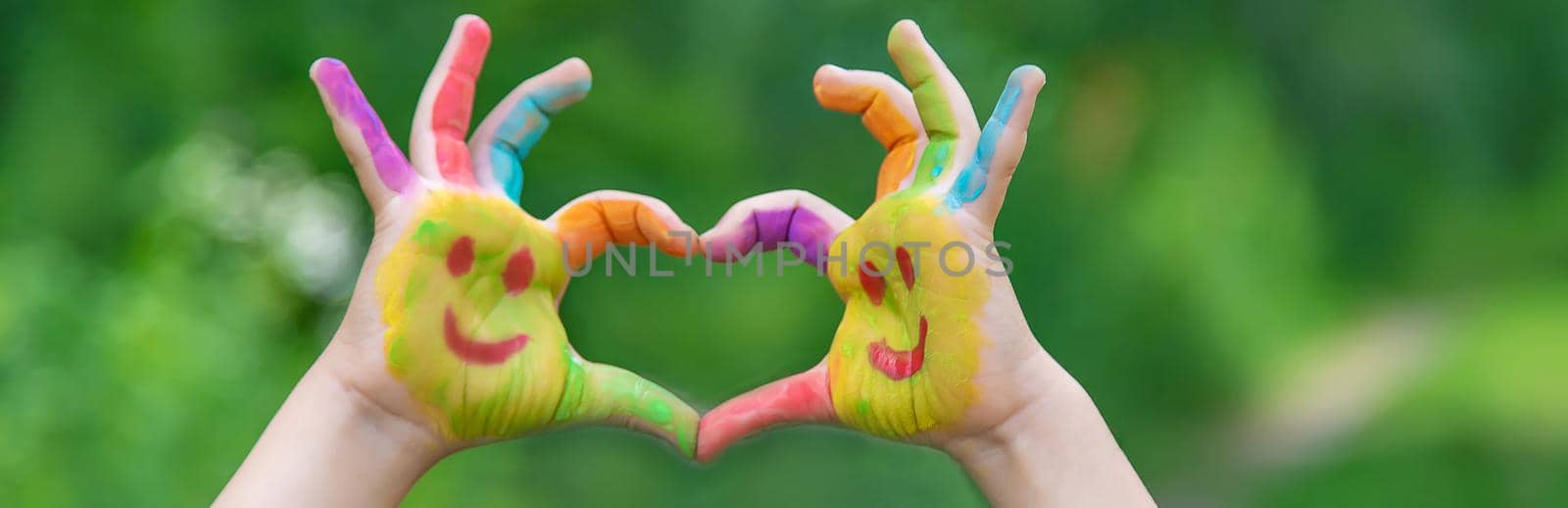 Children's hands in the colors of summer. Selective focus. by mila1784