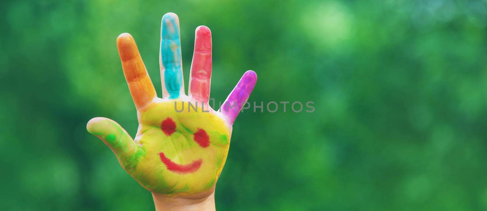 Children's hands in the colors of summer. Selective focus. by mila1784