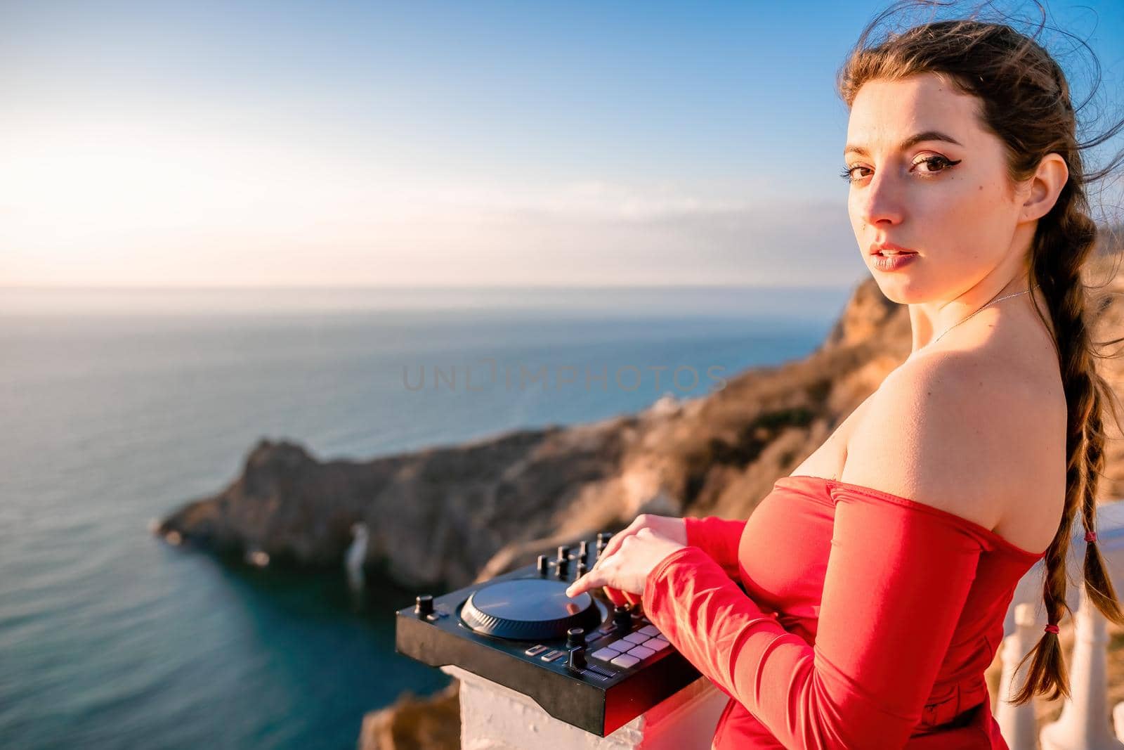 Female Hands of DJ plays music mixing and scratching on evening party. Professional music equipment. Close-up of a DJ console controlled by a young sexy woman. Selective focus.