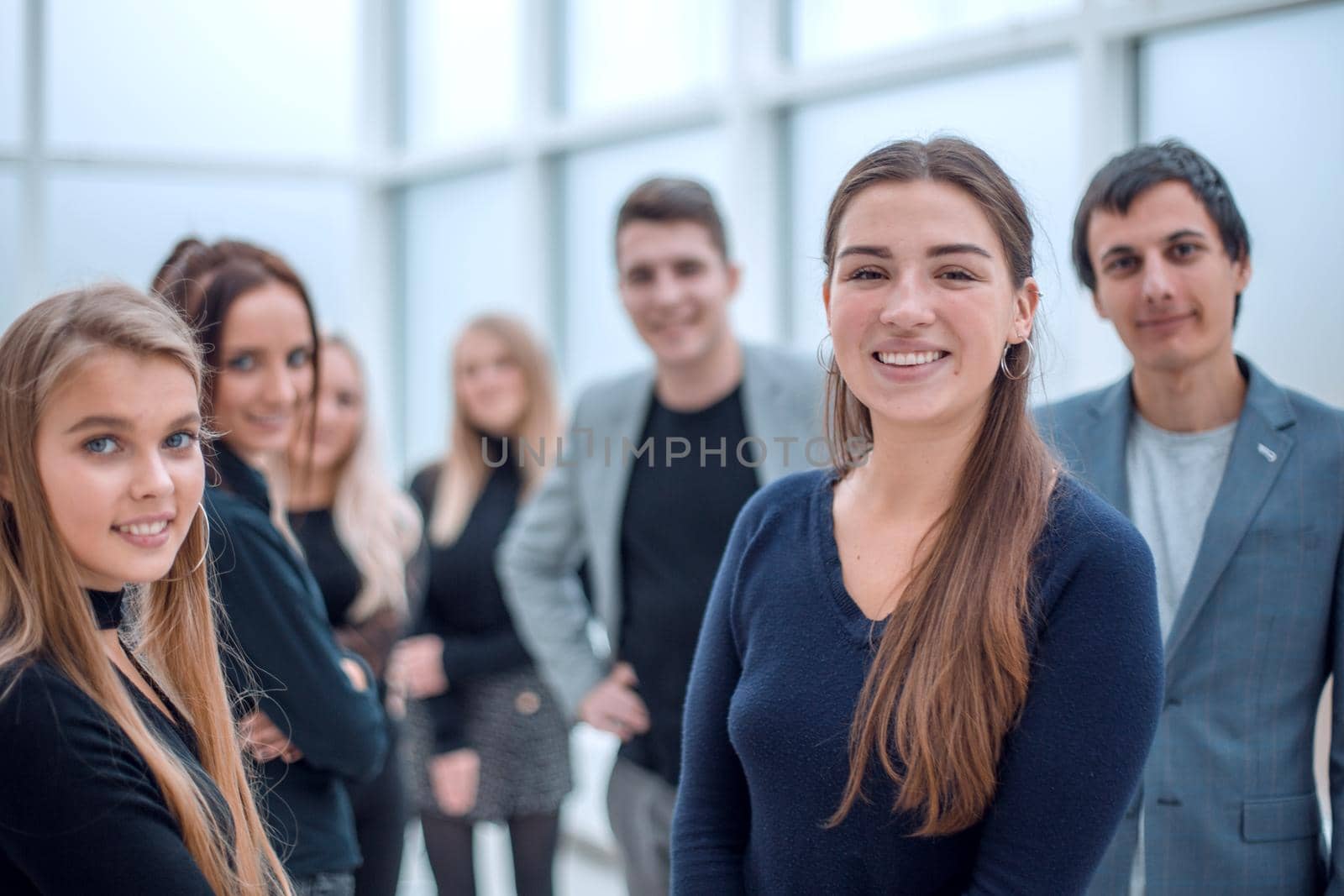 image of a young employee standing among her colleagues. office workdays