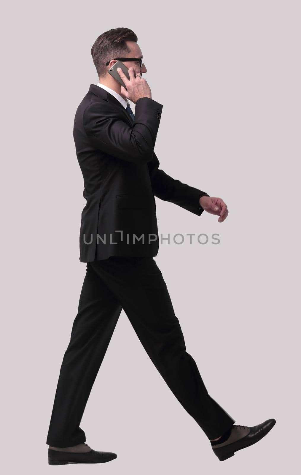 side view. businessman talking on his smartphone . isolated on white background