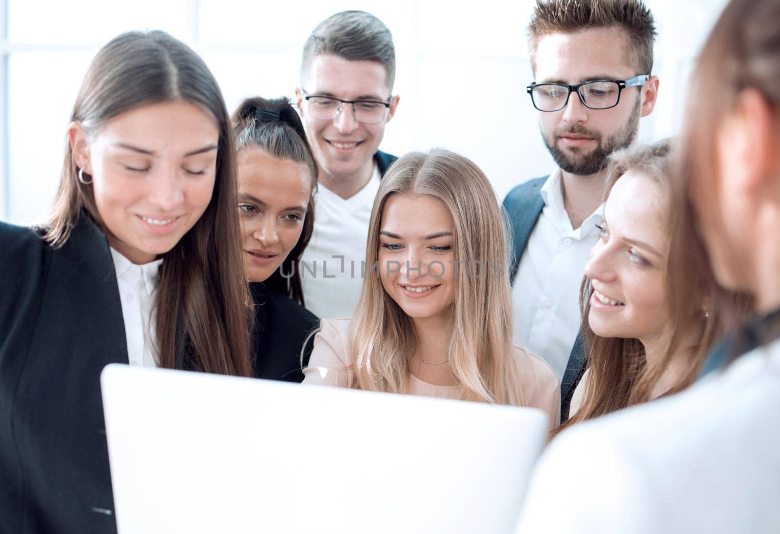 close up. a group of young employees looking at a laptop screen.