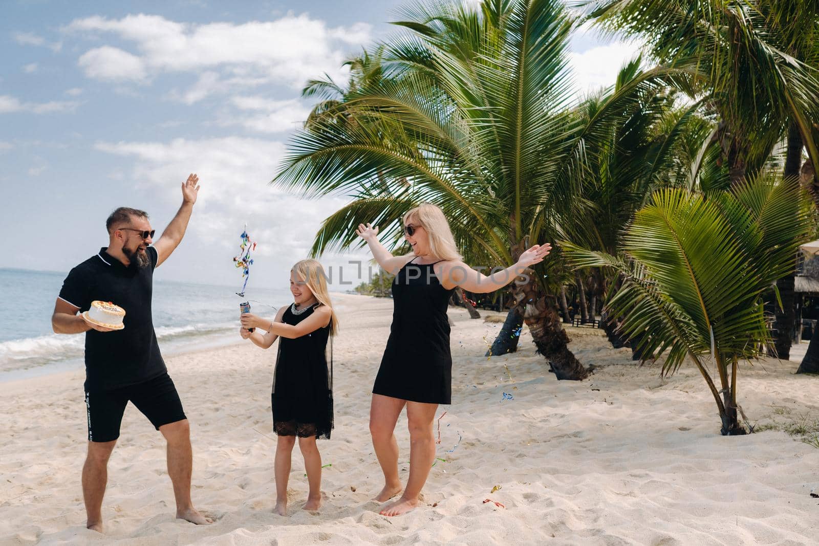 Happy beautiful family on a tropical beach celebrates the birth of their daughter.Family celebrates birthday on the island of Mauritius.