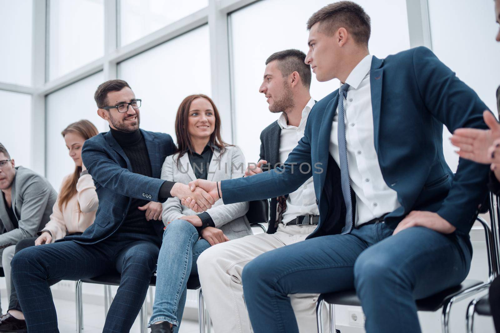 group of employees congratulating their colleague at a work meeting