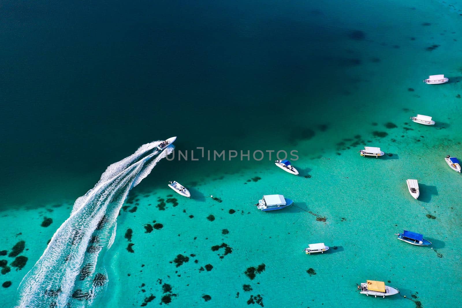 Top view of the Blue Bay lagoon of Mauritius. A boat floats on a turquoise lagoon.