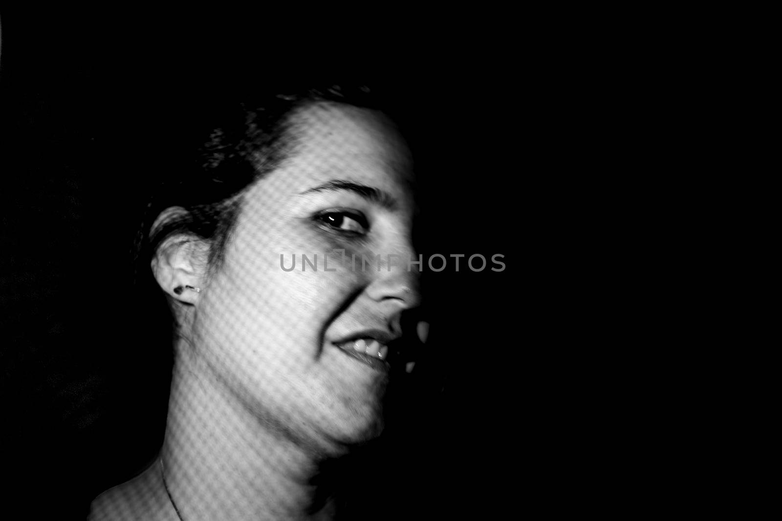 Portrait of the face of a young woman smiling in the foreground in a photographic studio. happy people concept