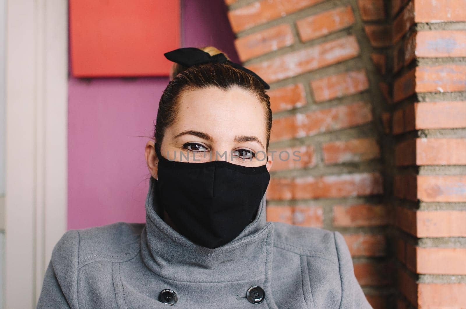 Close-up of a young woman with a surgical mask on her face against SARS-cov-2. by barcielaphoto