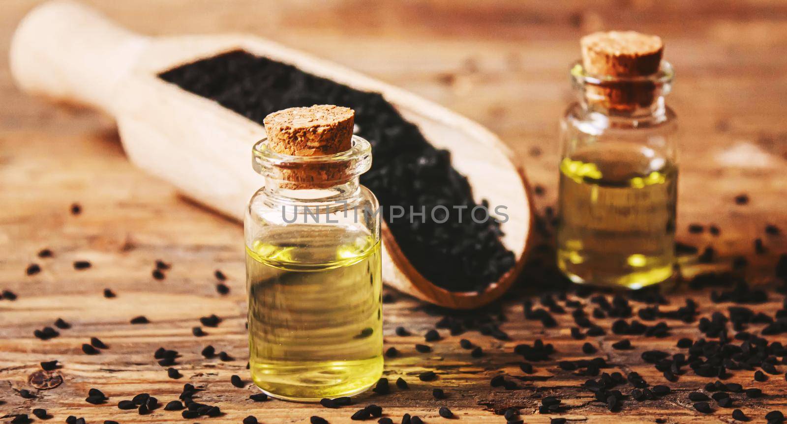 Black cumin essential oil in a small bottle. Selective focus. nature.