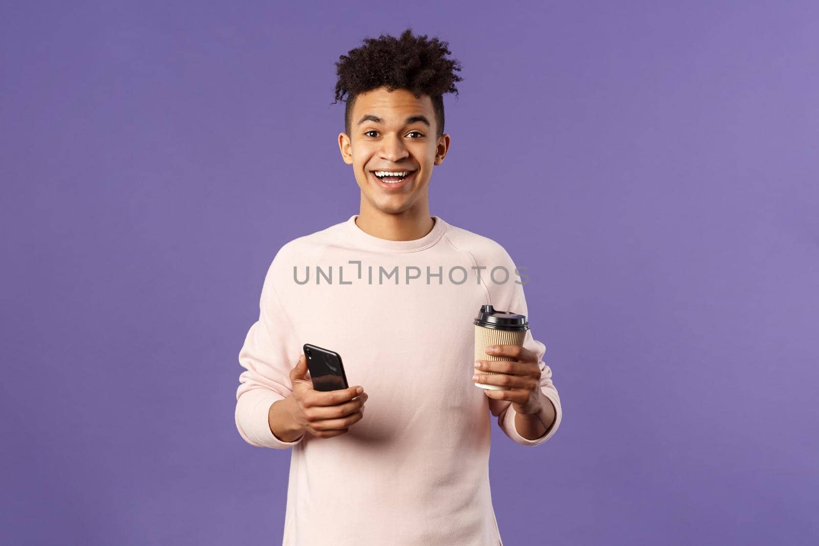 Waist-up portrait of happy enthusiastic hispanic man with smartphone, hold mobile phone and drinking coffee from take-away cup in office cafe, discuss recent project coworkers and team by Benzoix
