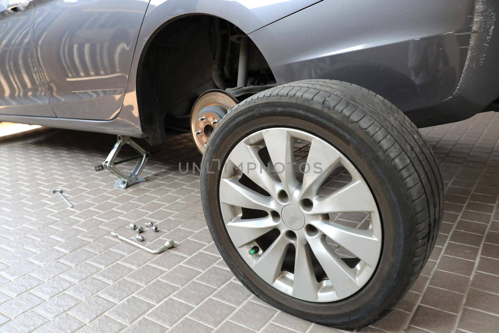 Disk brake and caliper in process of new tire replacement