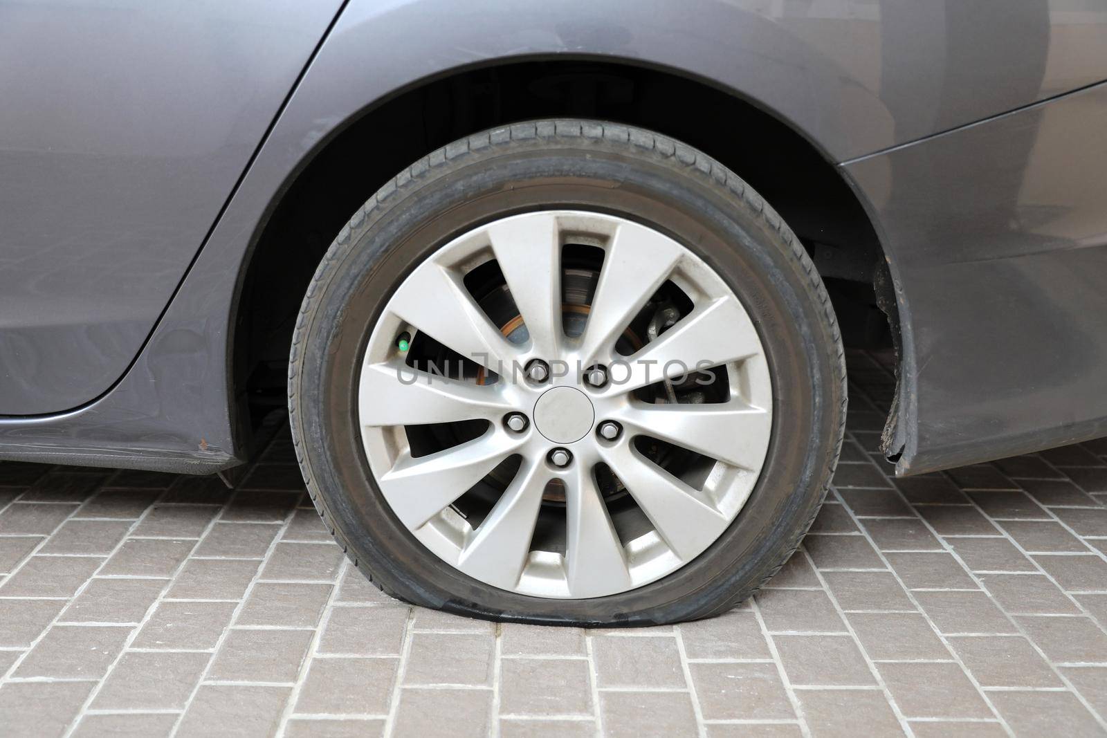 Car flat tire on tiled floor by drpnncpp