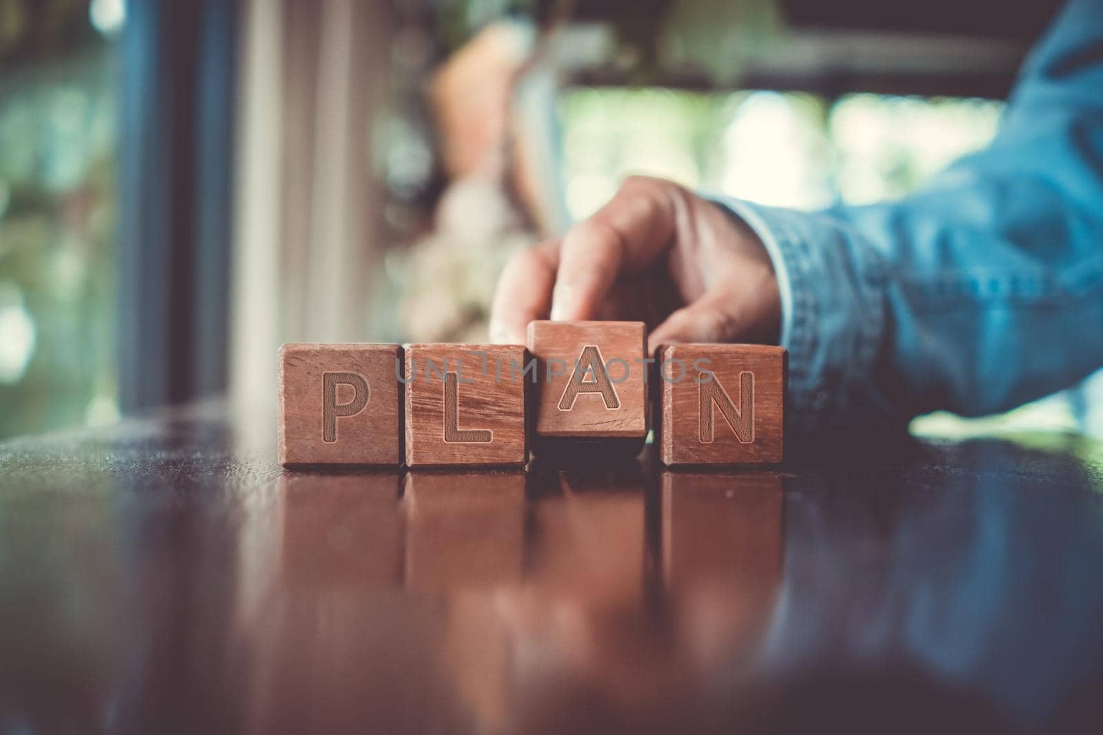 A group wooden cubes on table with word Plan on it background. by Suwant