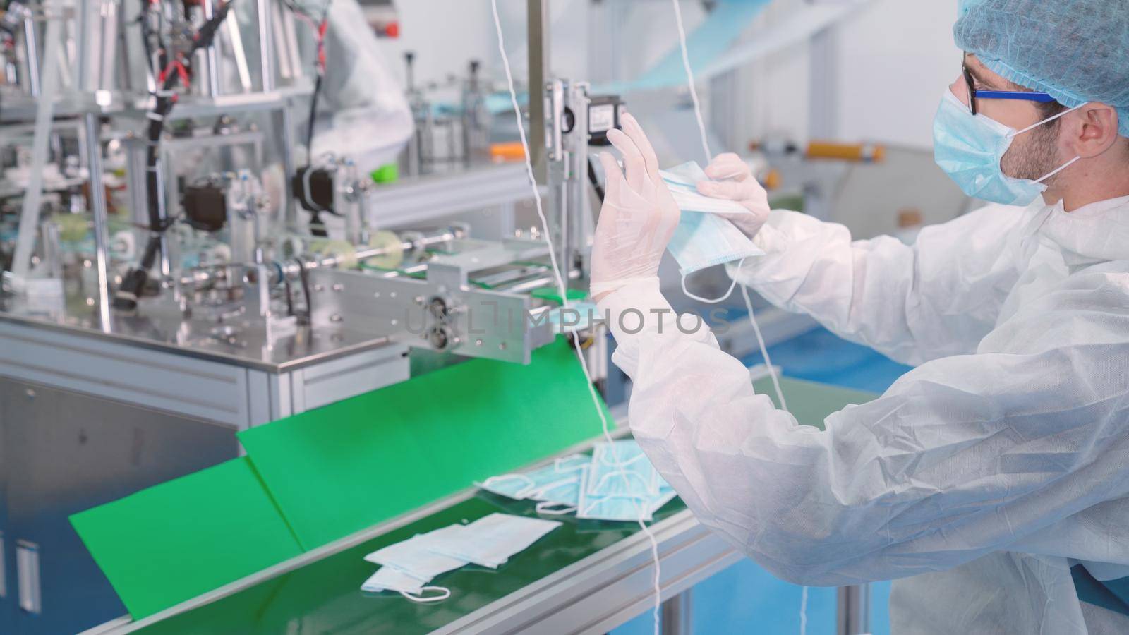 Face mask production line in modern factory . Concept of covid-19 coronavirus 2019 provention .