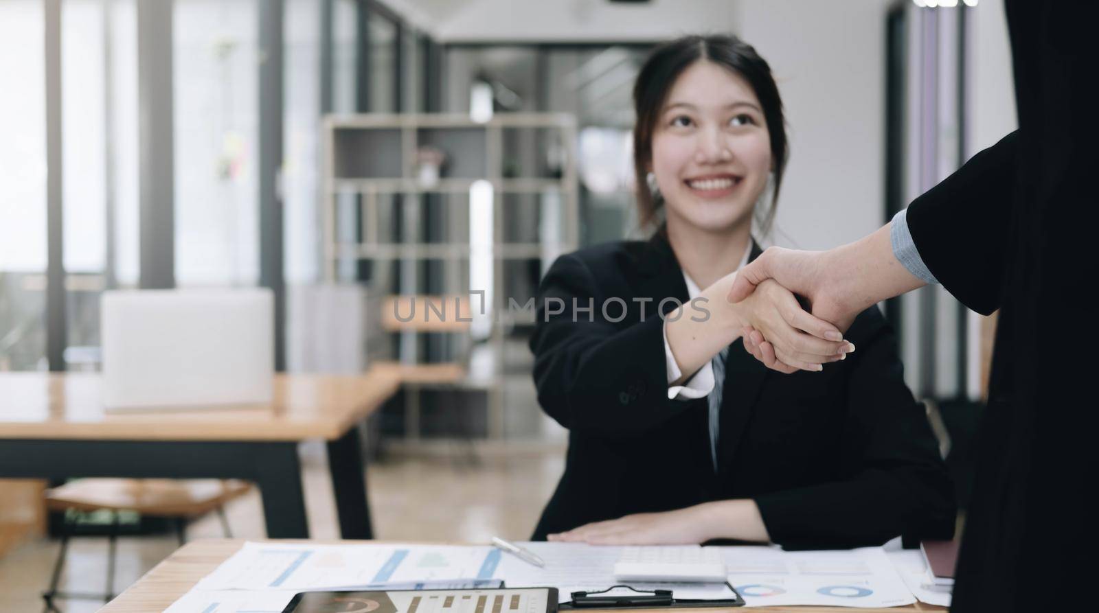 Portrait Asian Business people shaking hands, finishing up meeting, business etiquette, congratulation, merger and acquisition concept by wichayada