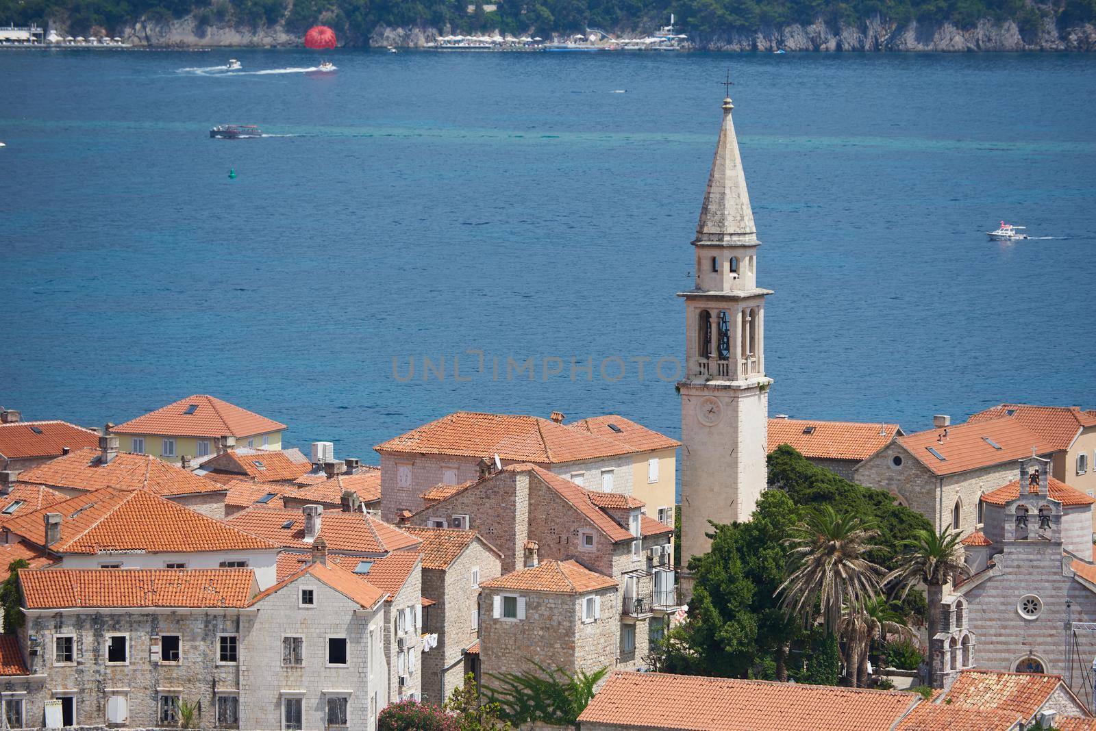 Old town with tower in Budva against sea by iceberg