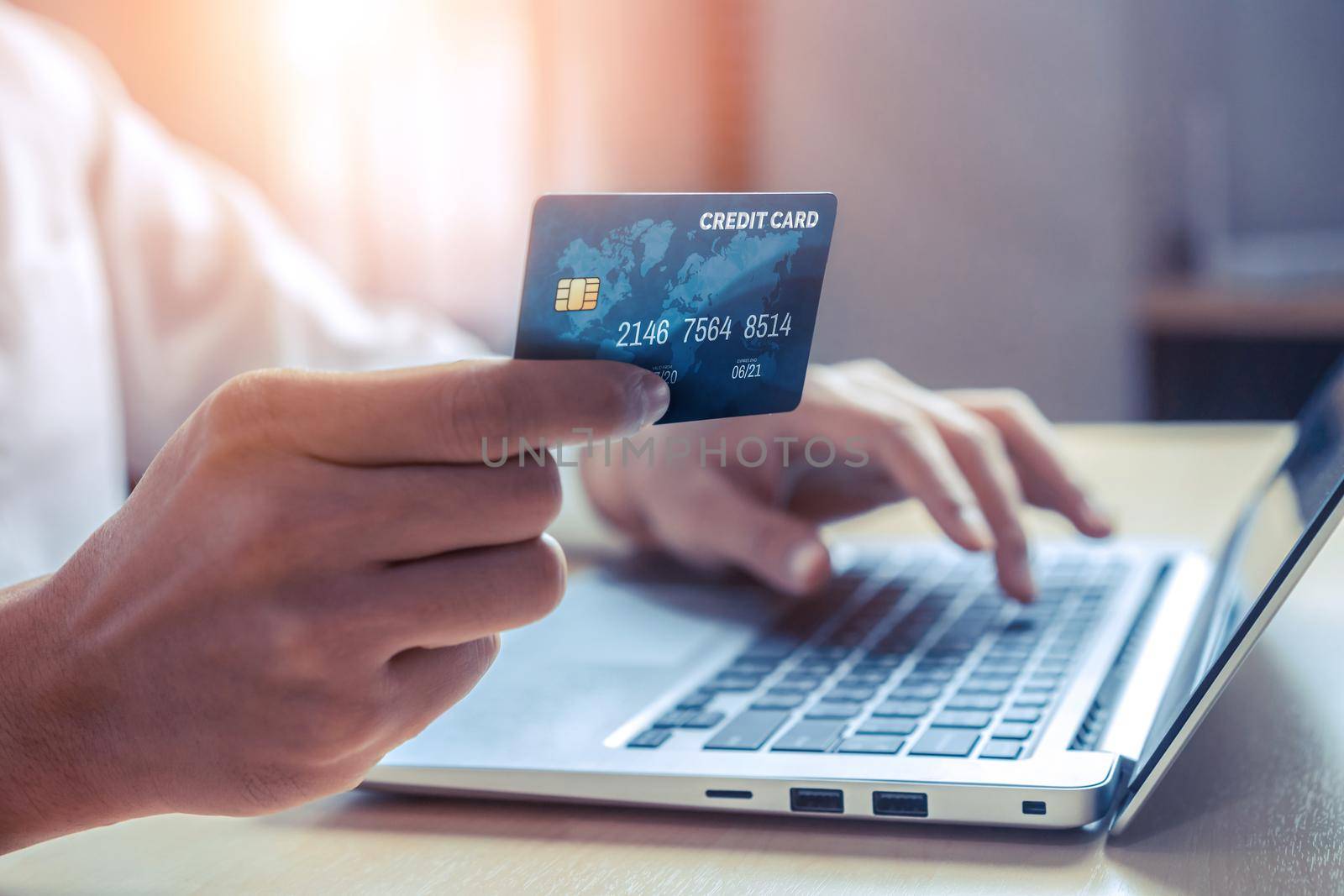 Young man use credit card for shopping payment online on laptop computer application or website. E-commerce and online shopping concept.