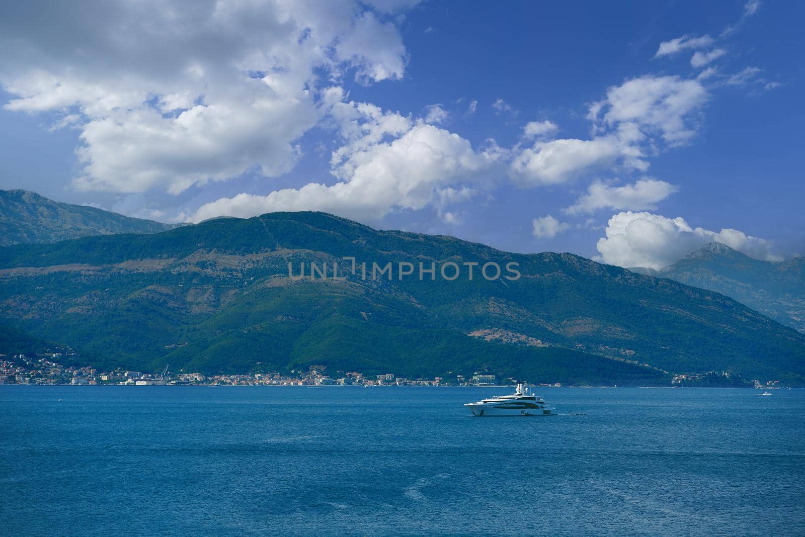 Seascape with luxury yacht against the backdrop of mountains in Montenegro.