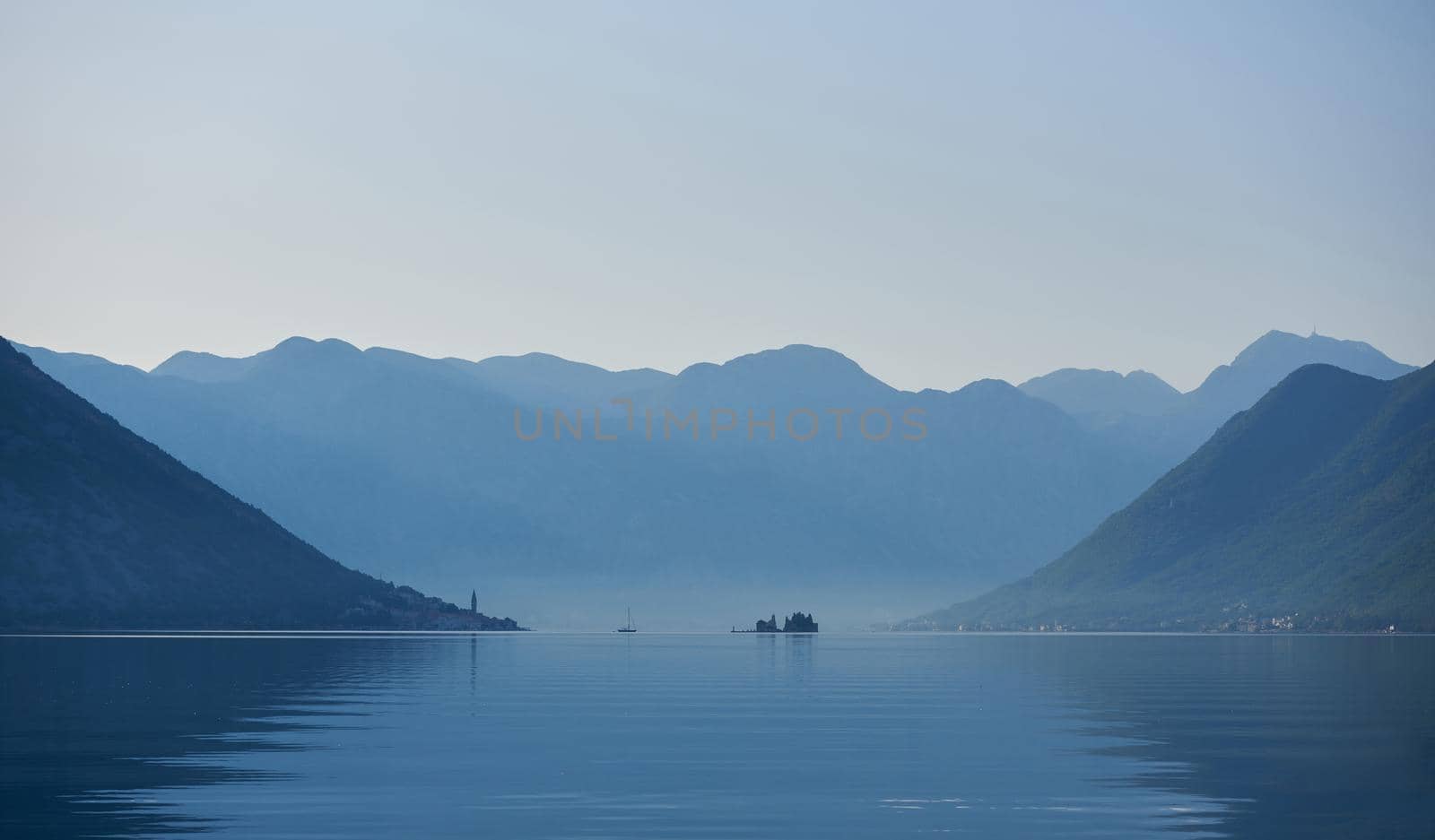 Landscape with a small island against the backdrop of mountains in Montenegro.