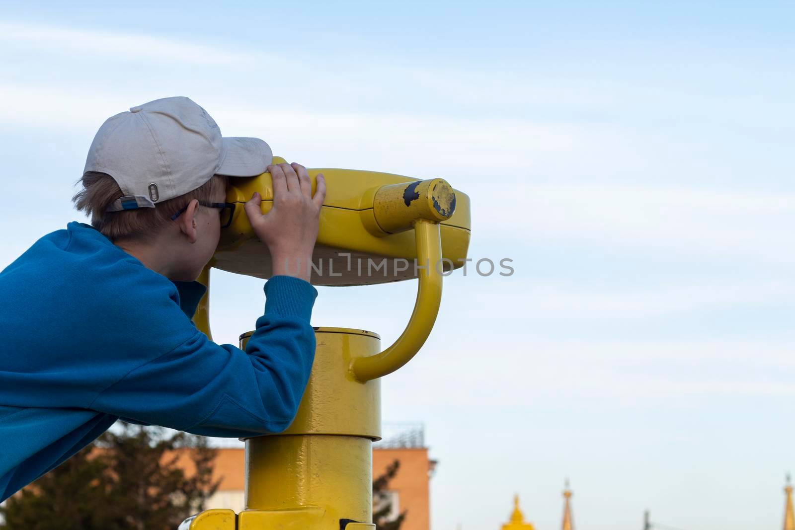 Boy looking through binocular at the city by AleksandraLevkovskaya