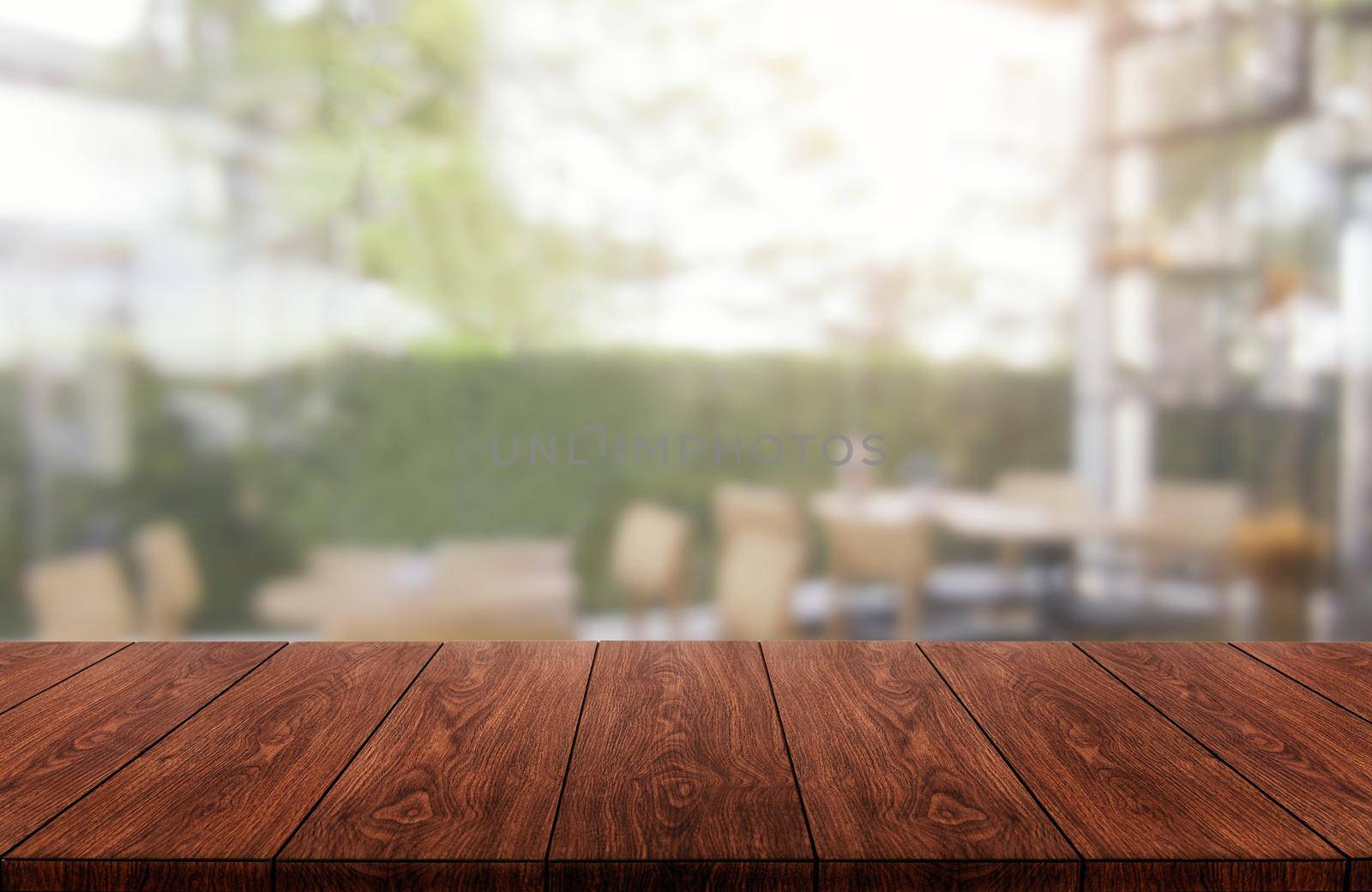 Wood table in blurry background of modern restaurant room or coffee shop with empty copy space on the table for product display mockup. Interior restaurant counter design concept.