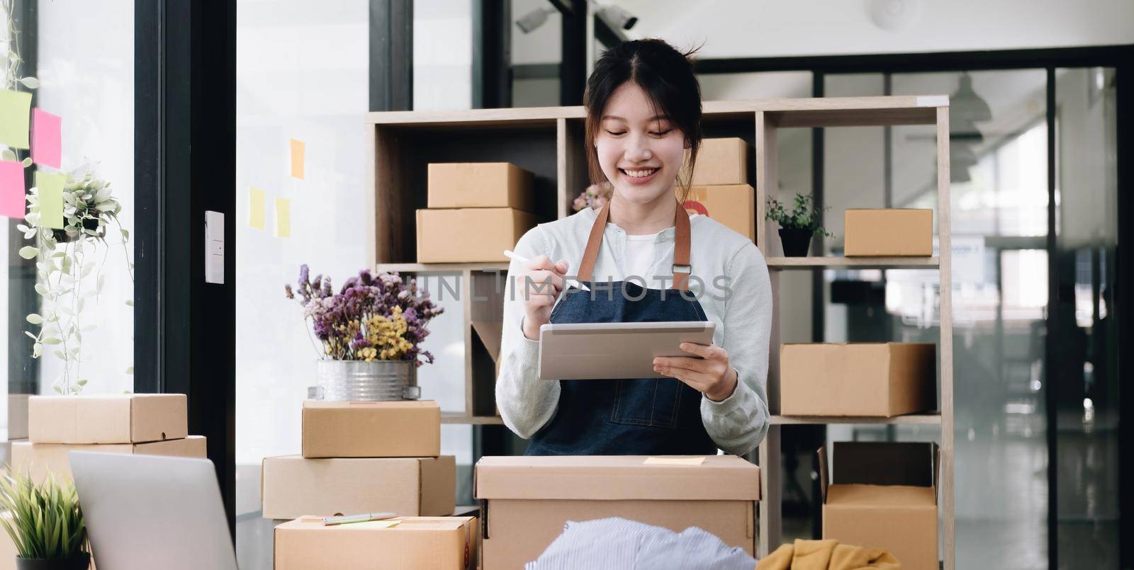 Small start-up business owners using computers at work, freelancers, saleswoman, checking production orders. Pack products for delivery to customers sell ecommerce delivery ideas by wichayada