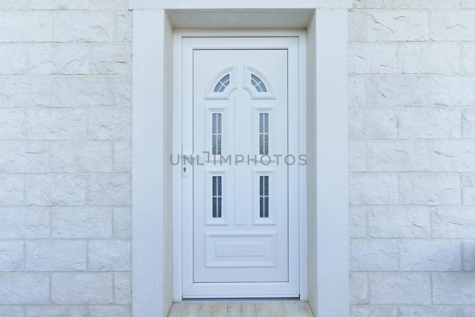 White front door and stone wall in a residential building by iceberg