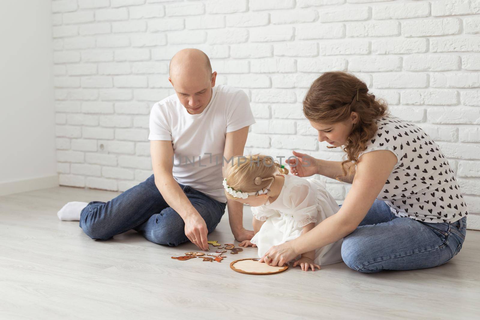 Baby child with hearing aids and cochlear implants plays with parents on floor. Deaf and rehabilitation concept by Satura86