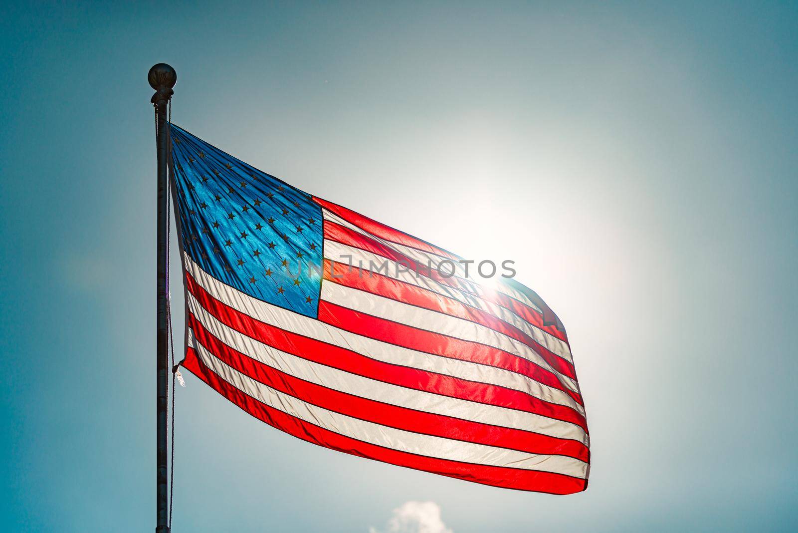 US american flag and blue cloudy sky with clouds in background