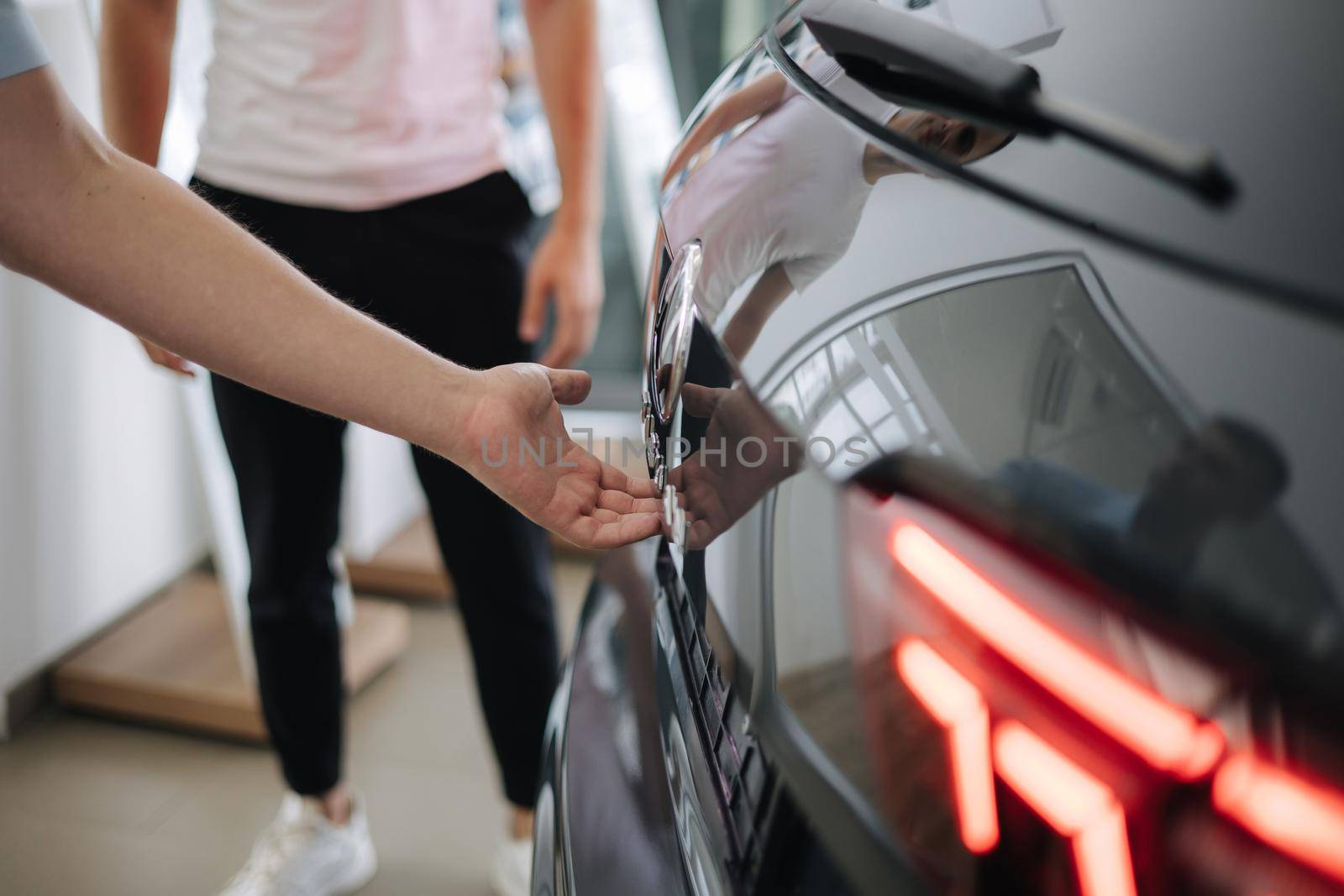 Close-up of different elements car exterior design. Back view of car. Man open the trunk.