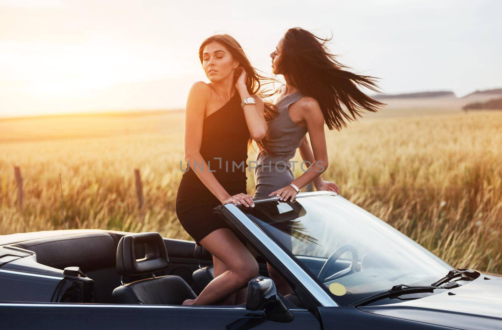 Two women in a black car on the roadside roads.