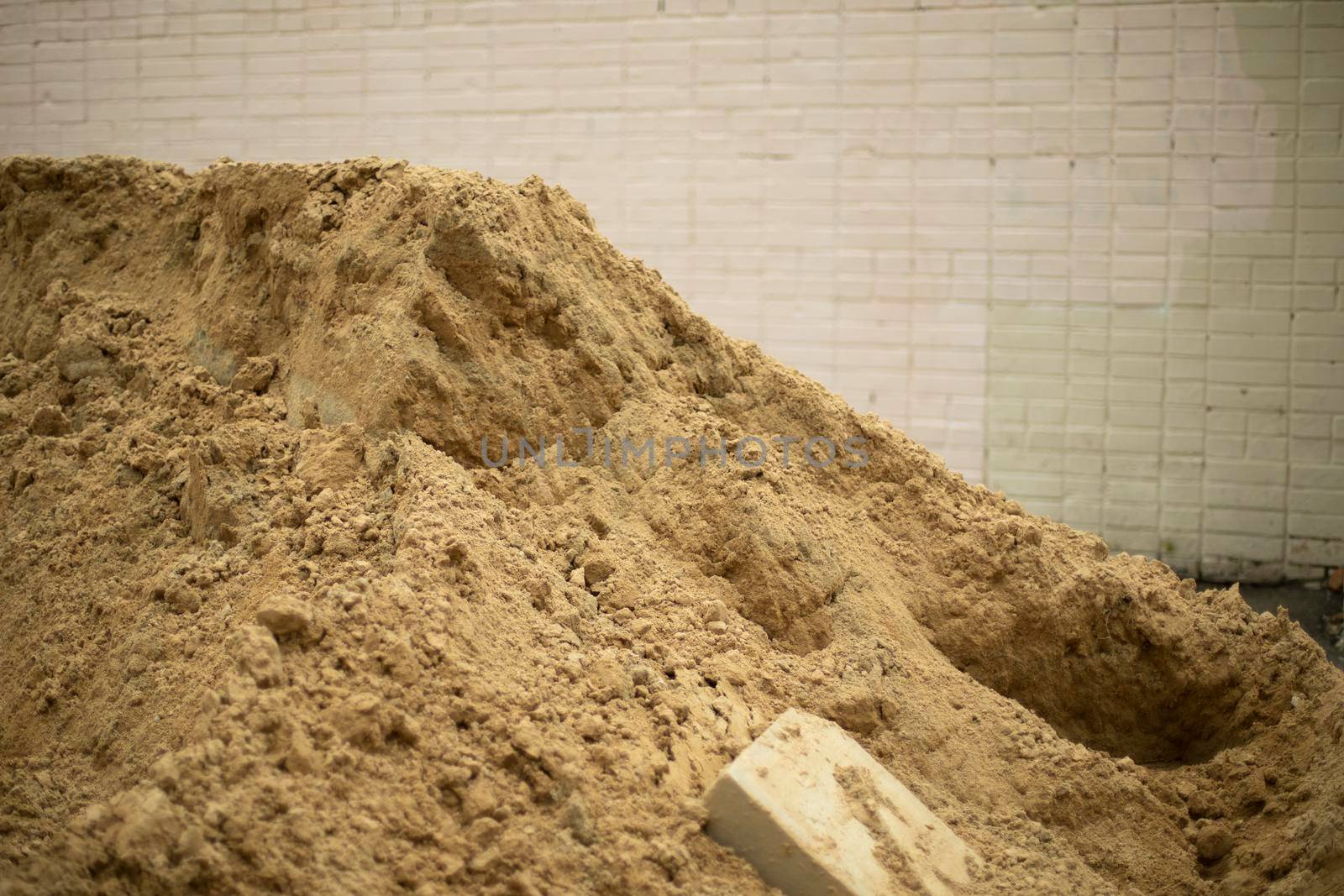 Construction sand. Pile of sand at construction site. Small bulk material of natural origin.