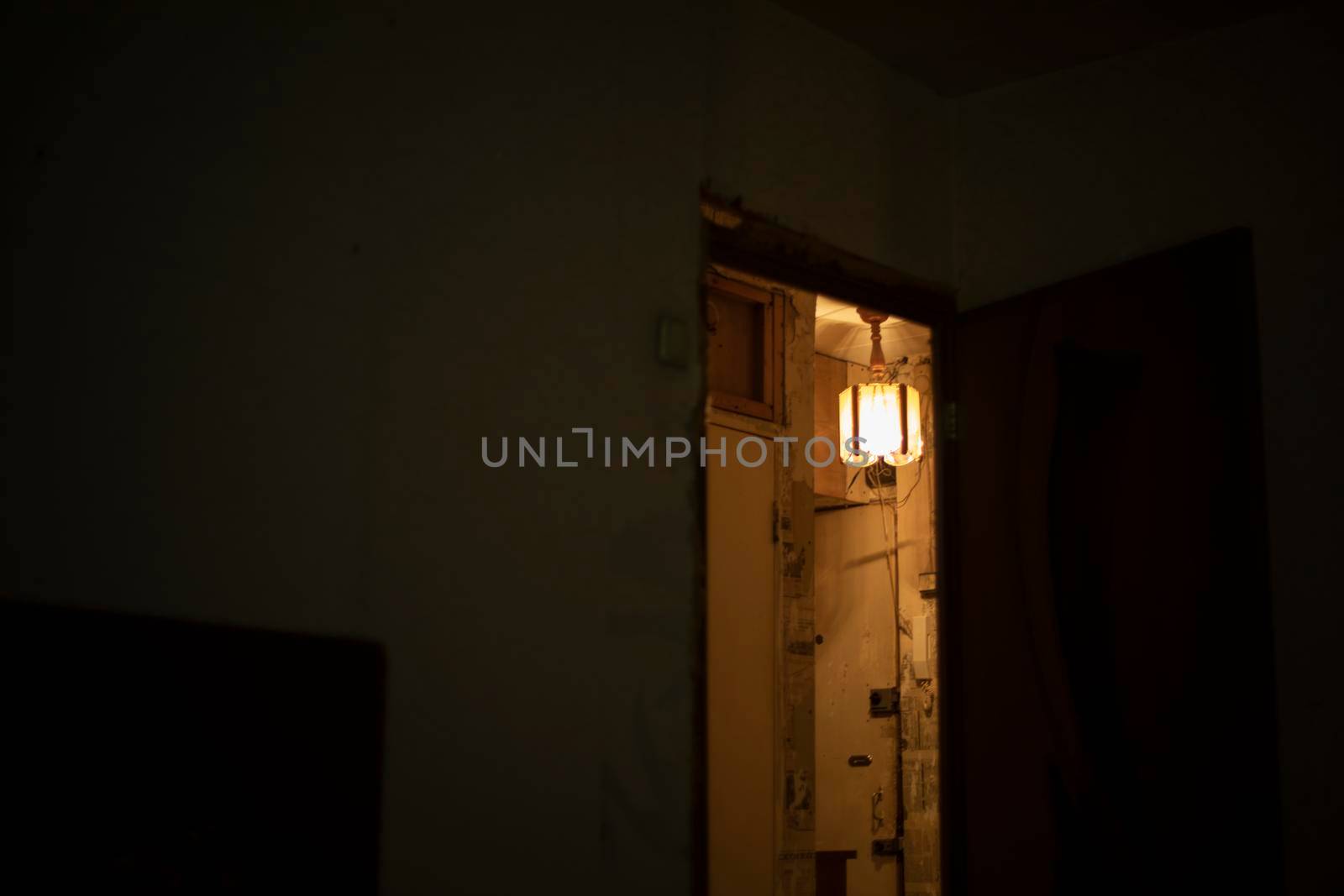 Light in room. Interior details. Lamp shines on ceiling. Doorway in house.