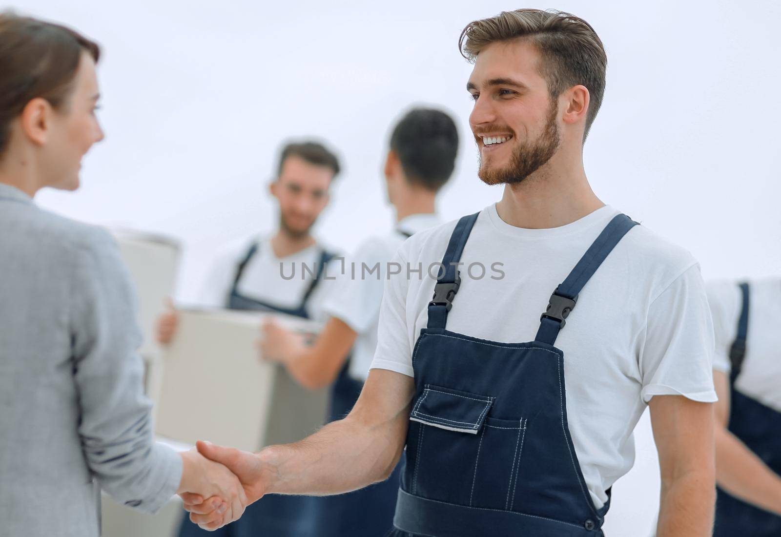 Manager with clipboard shaking hands with movers.