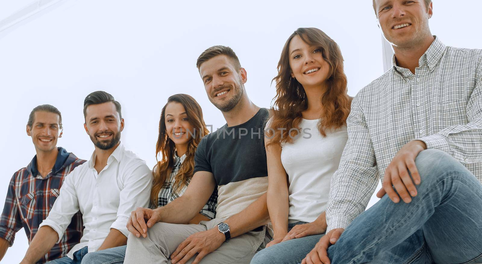 Group of young creative people sitting on chairs in waiting room