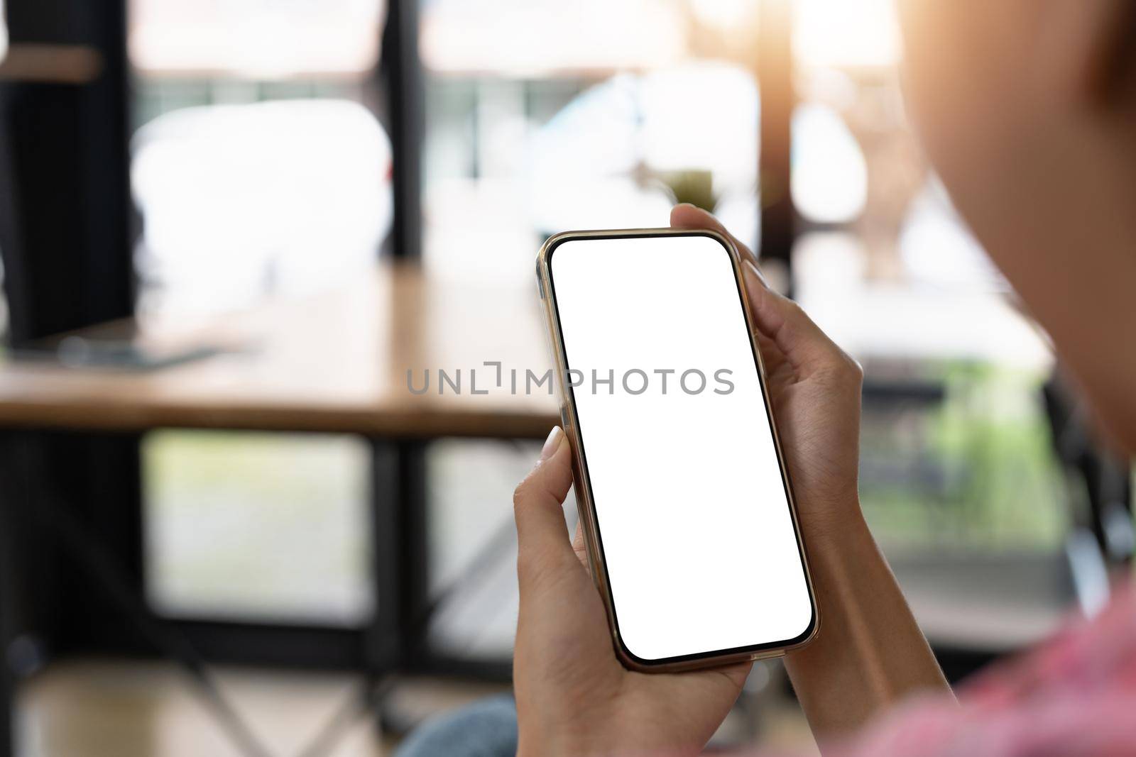 Mockup image of a beautiful woman holding and showing a mobile phone with blank white screen