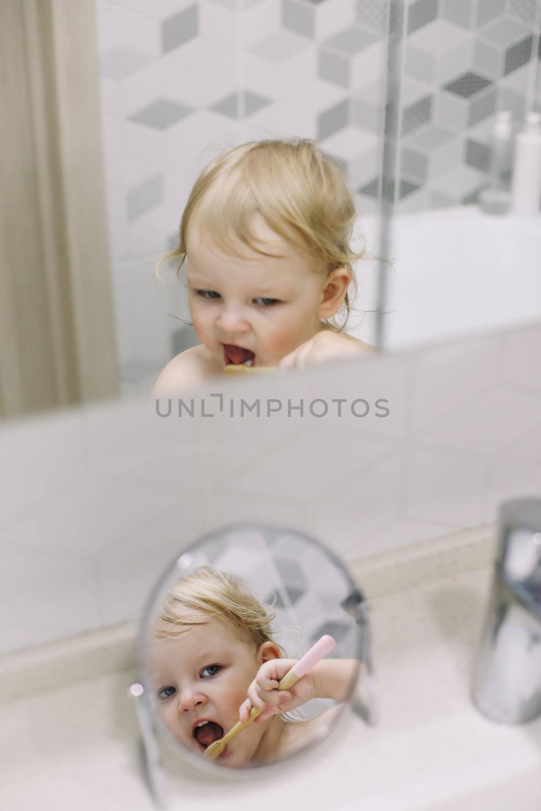 reflection in the mirror of a little funny girl brushing her teeth by paralisart