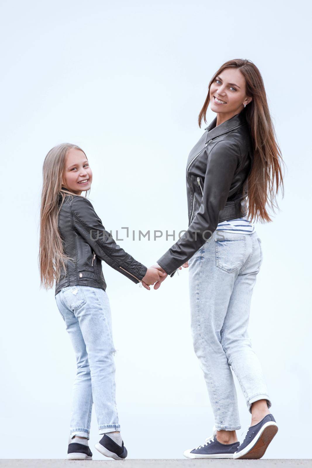rear view. happy mother and daughter walk together. photo with copy space