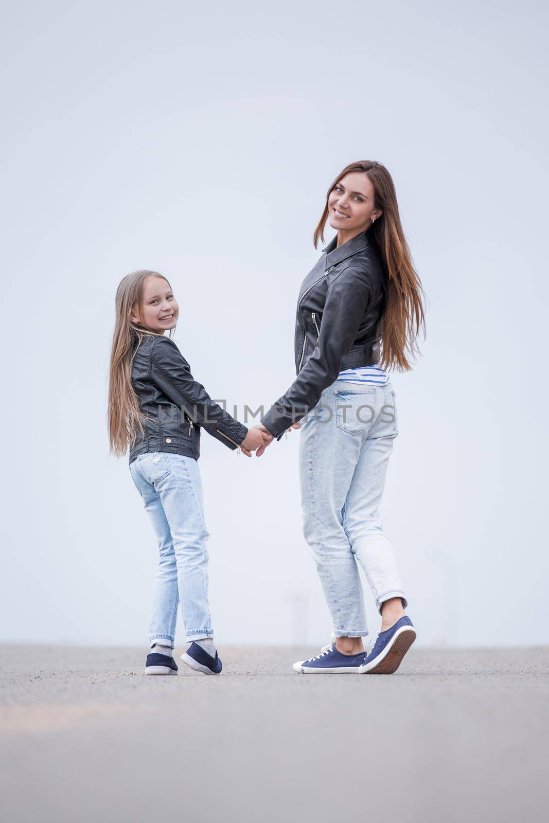 rear view. happy mother and daughter walk together. photo with copy space