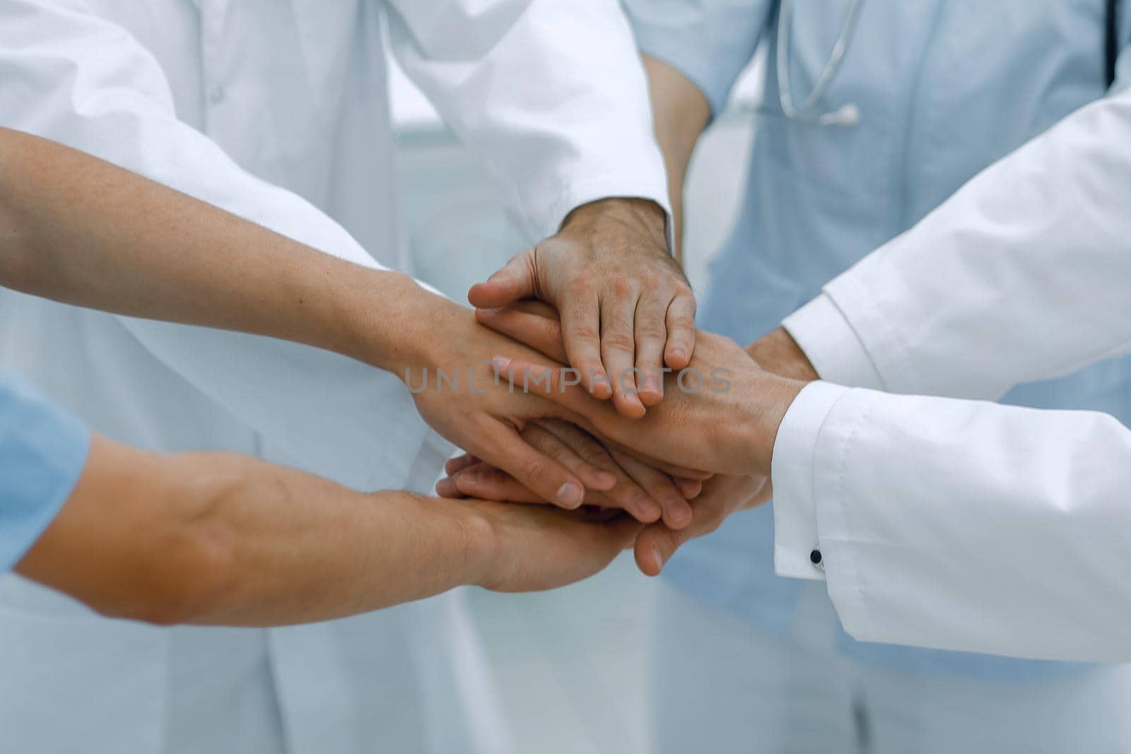 doctors holding hands together at hospital.concept of teamwork