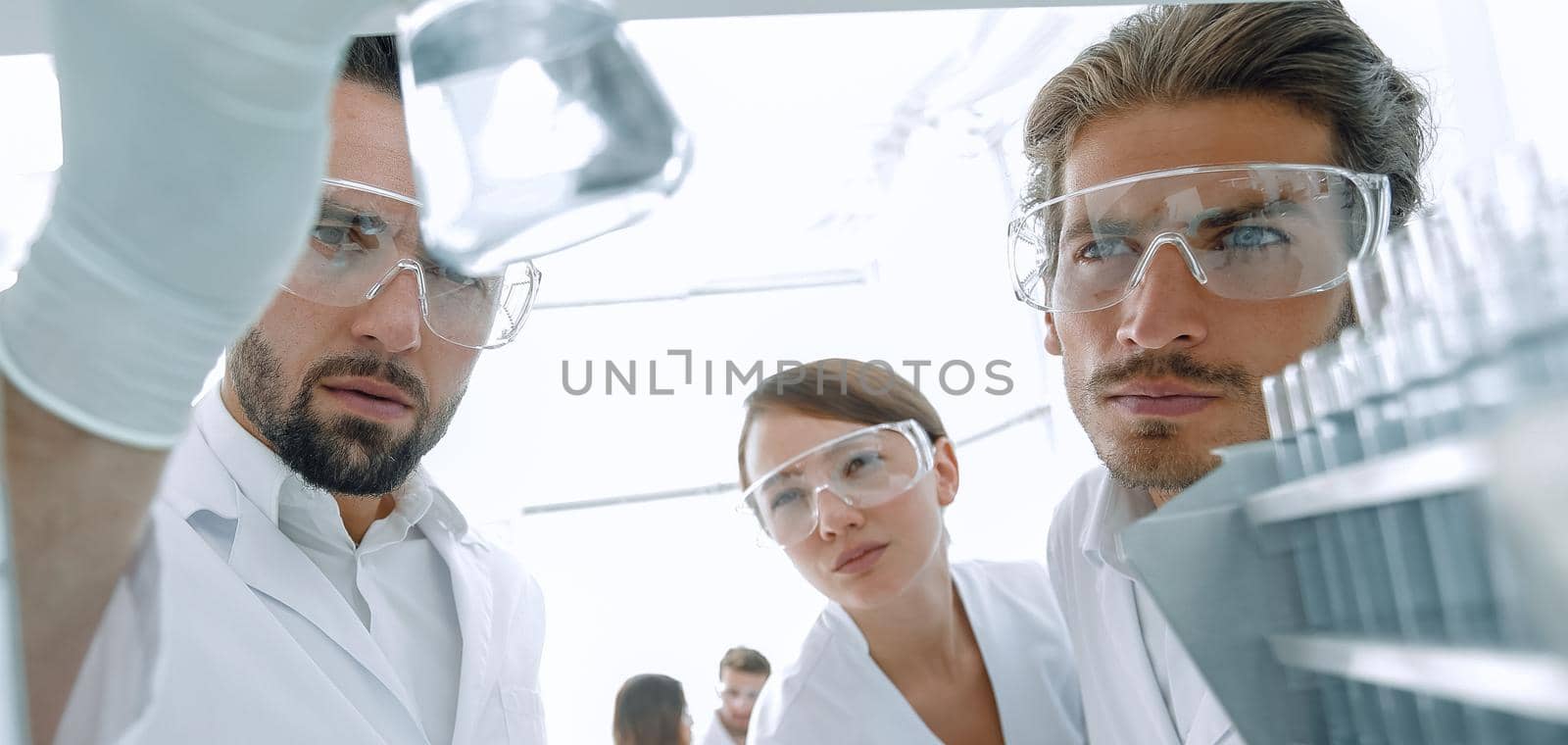 closeup. scientist and assistant studying the liquid in the glass tube