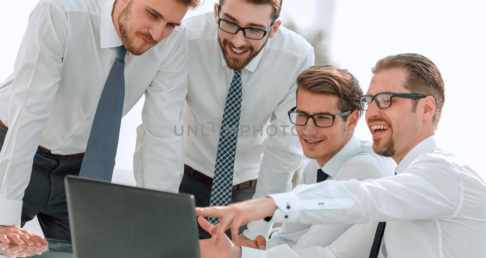 business team looks at the laptop screen. people and technology
