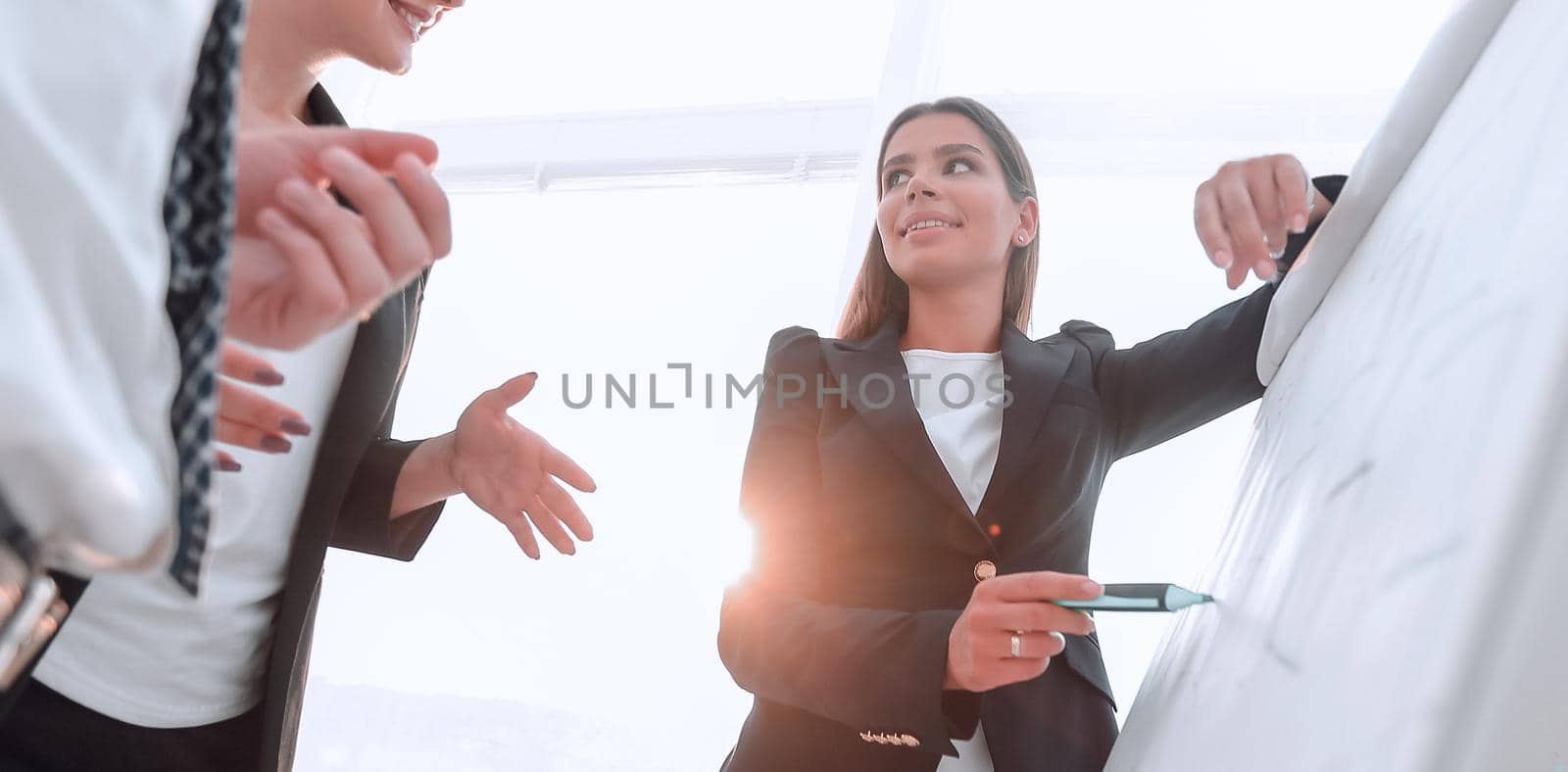 business woman pointing with a marker on the flipchart by asdf