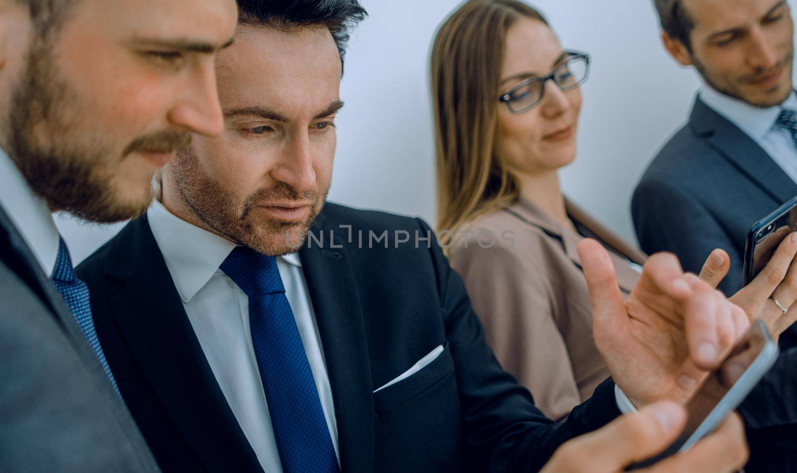 Group of young Businessman and Businesswoman looking at their smartphones and discussing for their project. Business and internet concept.