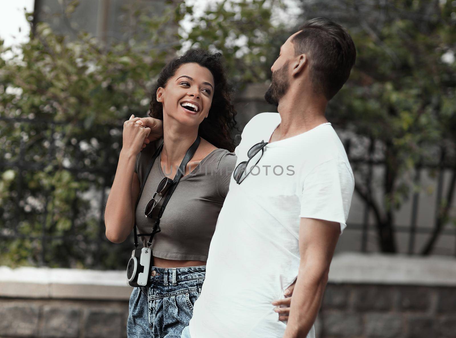 Happy young couple walking in the summer park