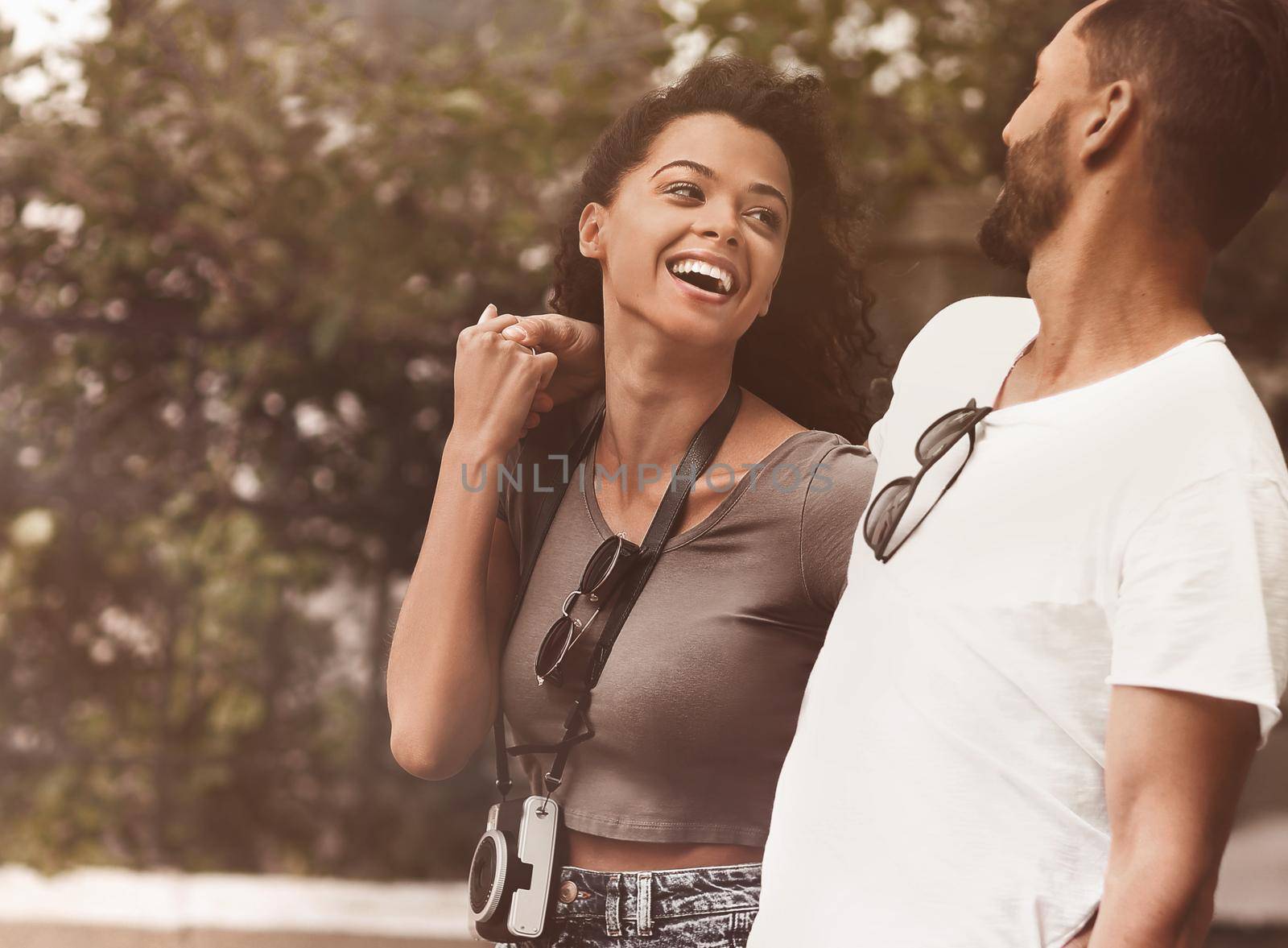 Happy young couple walking in the summer park