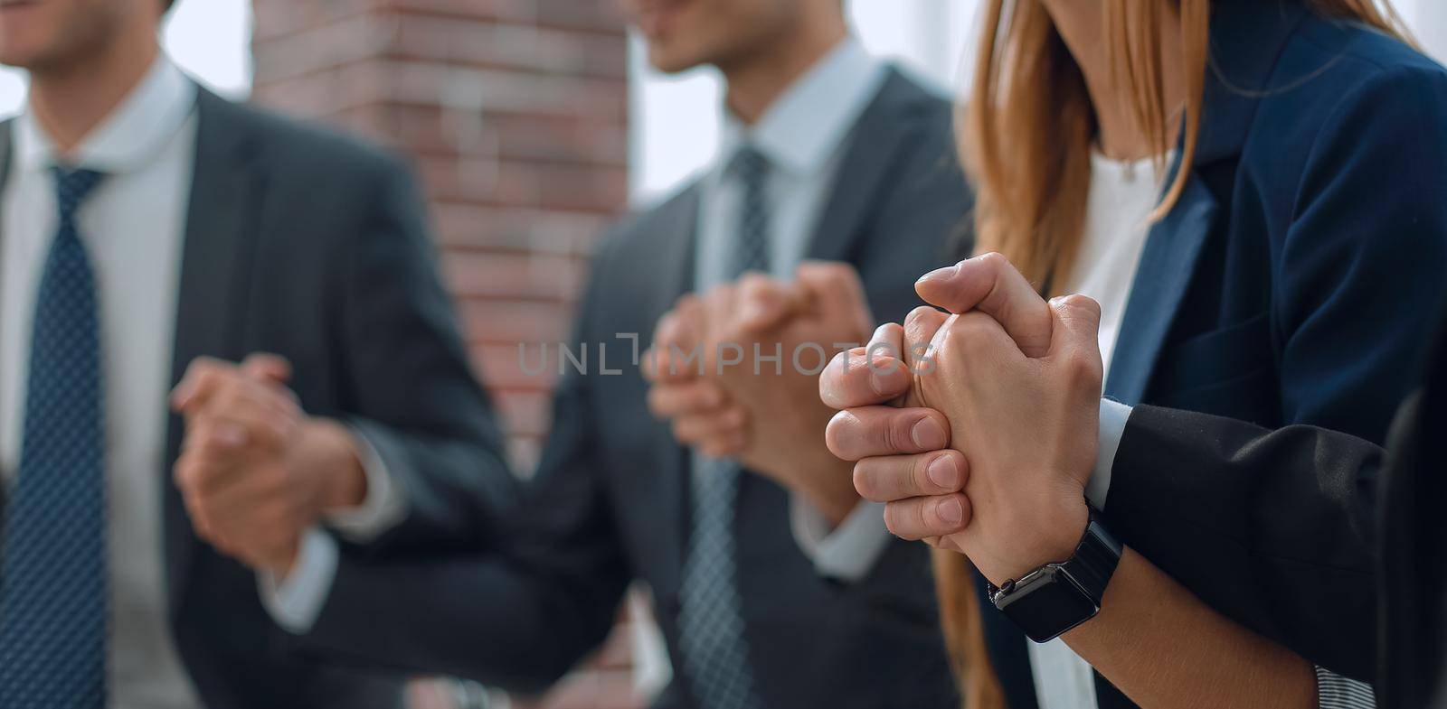 A group of businessmen holding hands in a circle by asdf