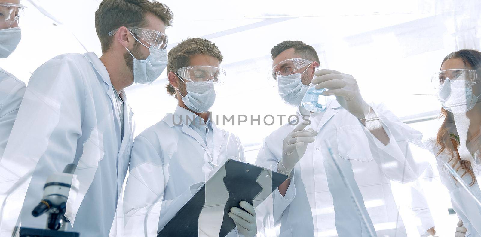 group of scientists working with test tubes and microscope in the laboratory.