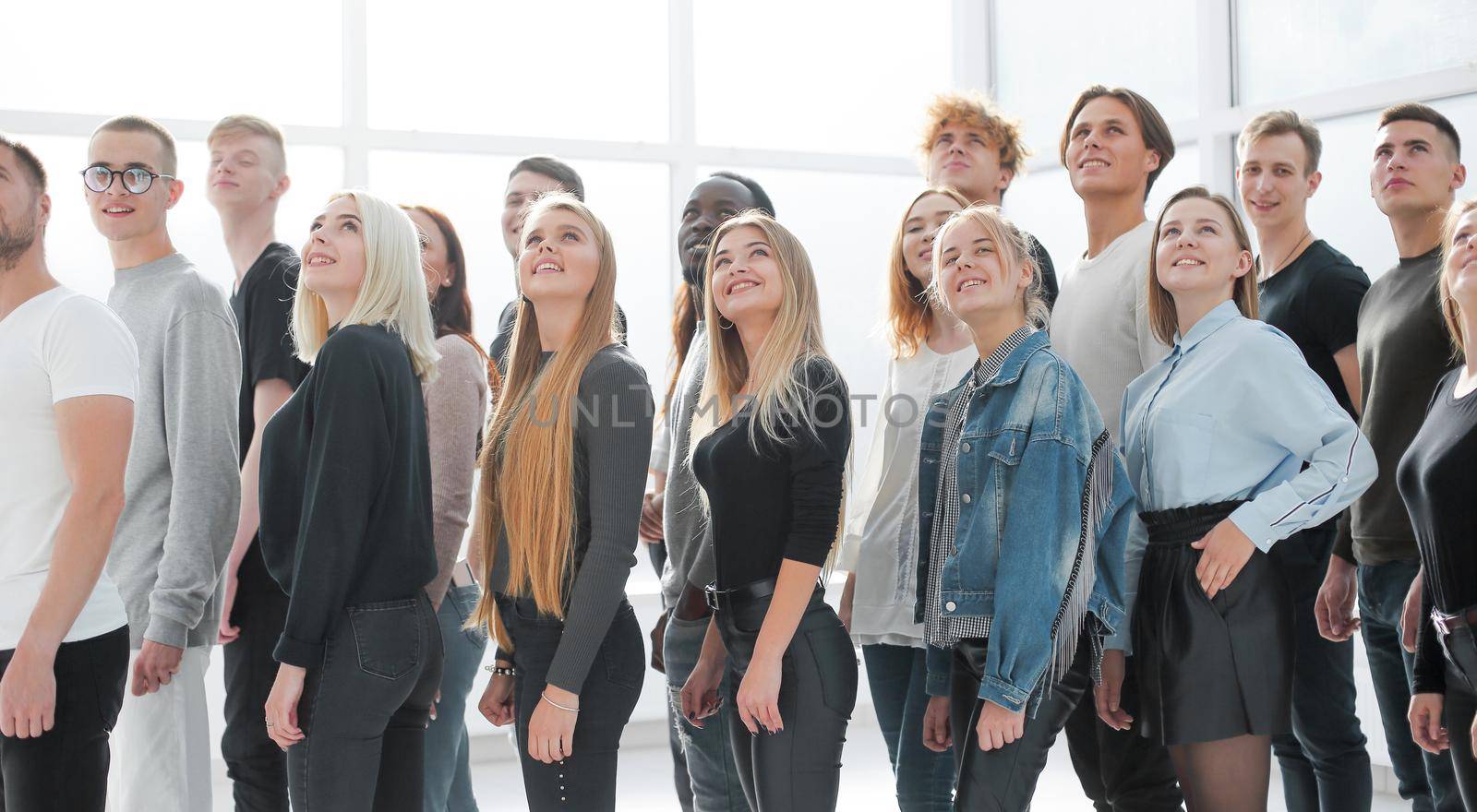 side view. organized group of casual young people looking up