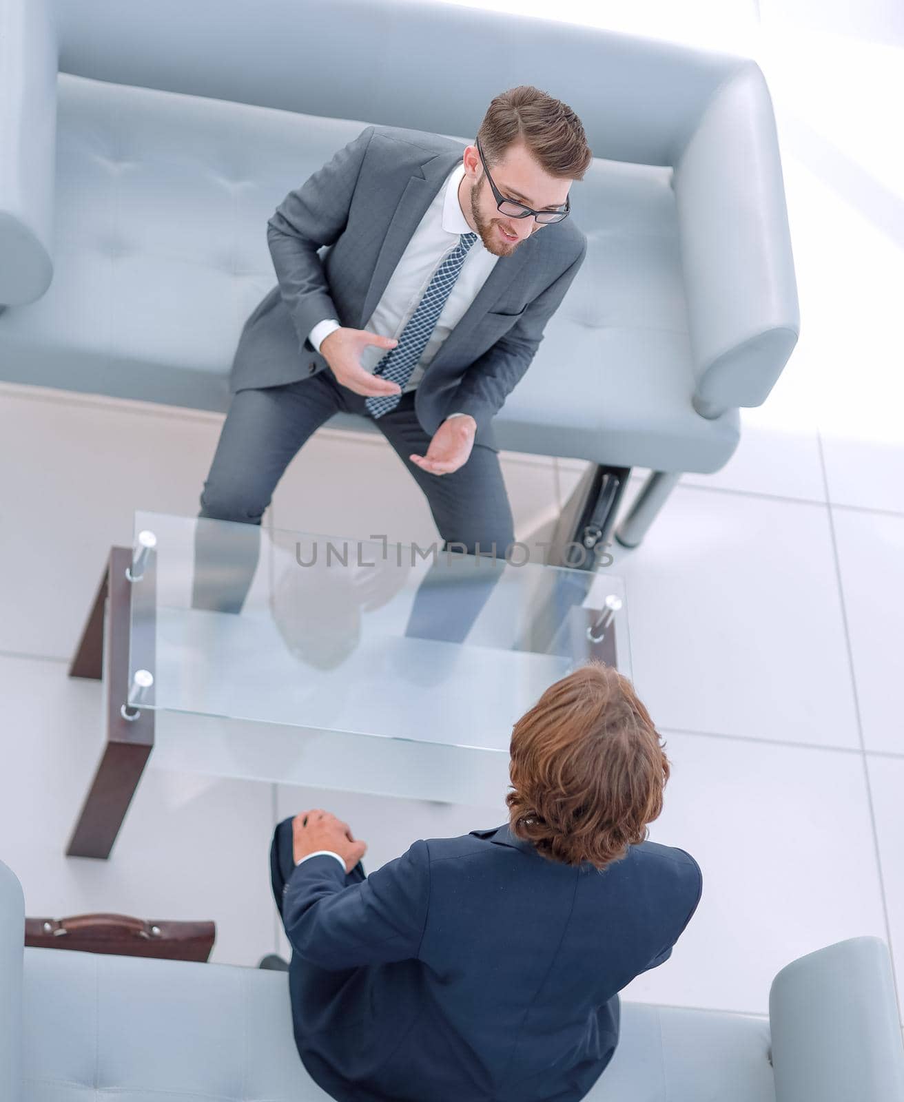 Two serious businessman talking in office.vertical photo
