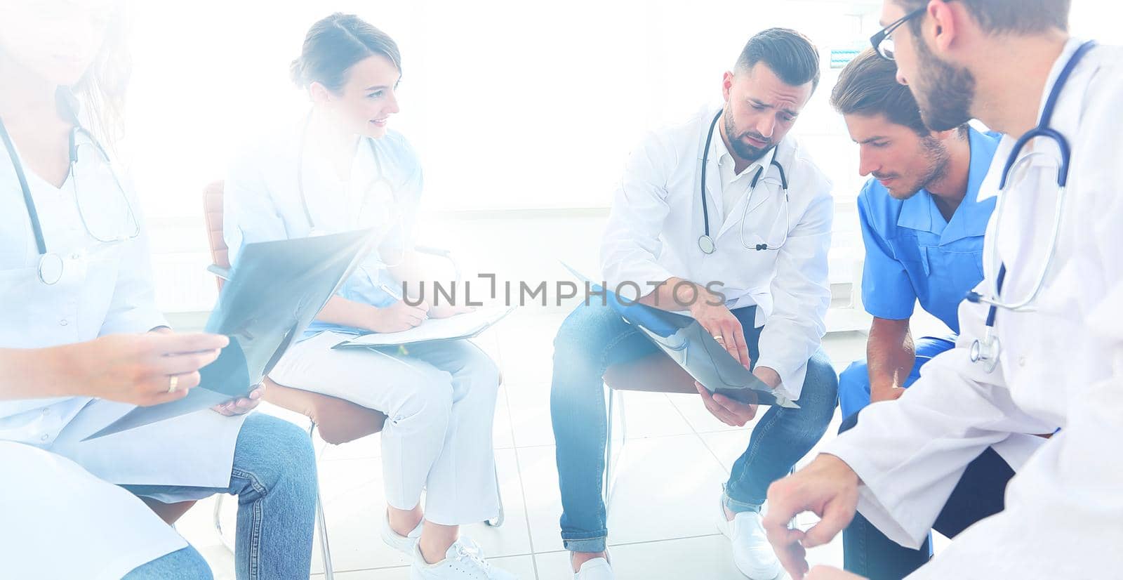 radiologists and a surgeon discussing a radiograph of a patient sitting in the office.
